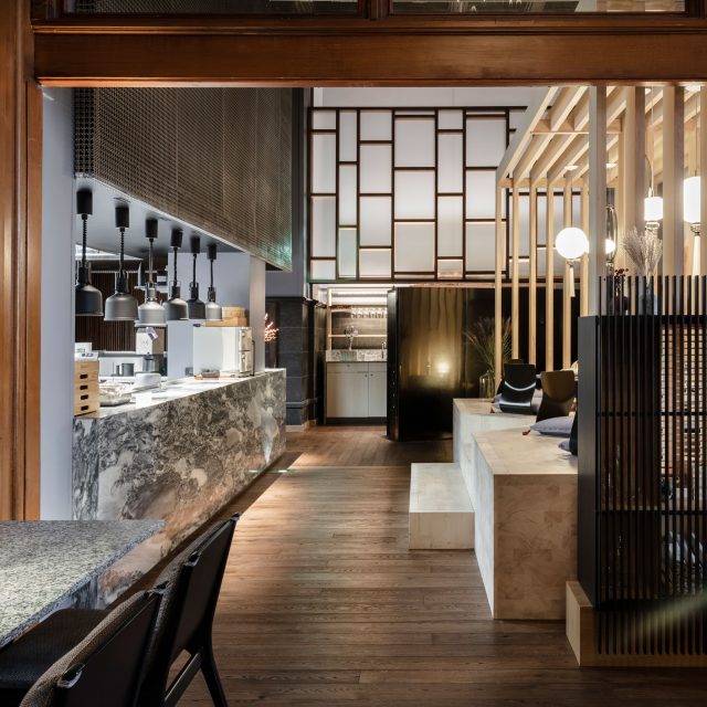 Vrå interiör japansk sittning med utsikt över kök i sten och trä